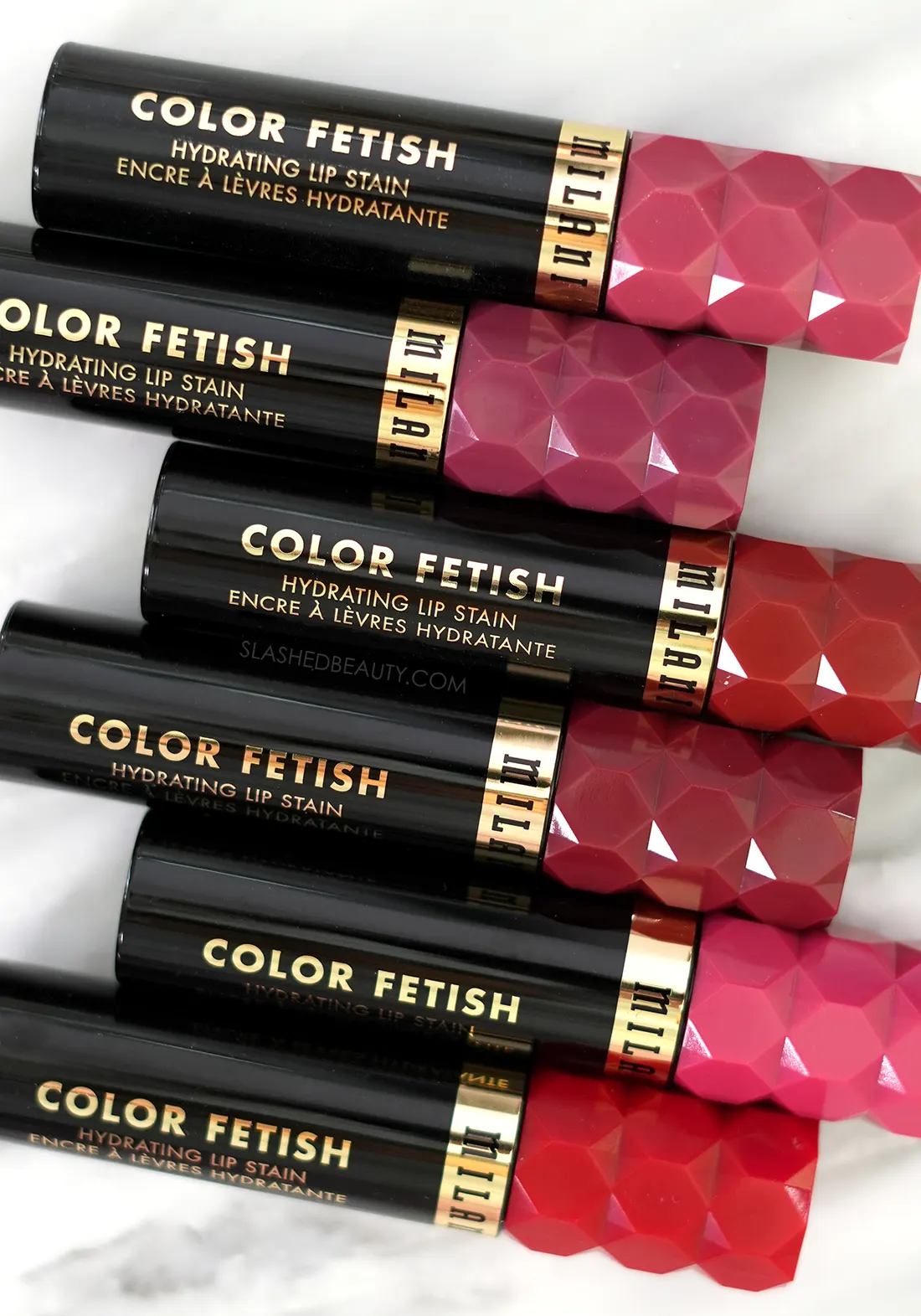 Milani Color Fetish Hydrating Lip Stains lying side by side on marble
